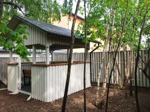 a pergola on a white building with a fence at Marbella Rezidence in Ventspils