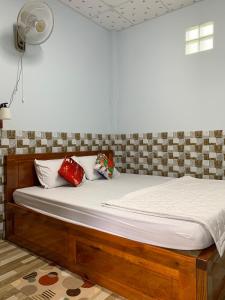 a bedroom with a wooden bed with pillows on it at Thảo Trân in Ha Tien