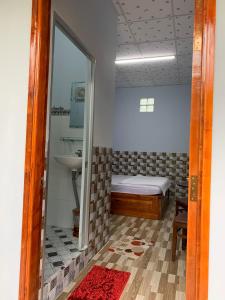 a small room with a bed and a mirror at Thảo Trân in Ha Tien