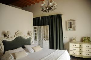 a bedroom with a white bed and a chandelier at Poggio Alle Lame in Tavarnelle Val di Pesa