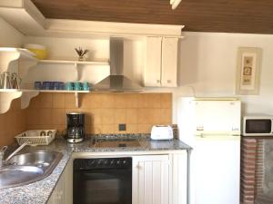 a kitchen with a sink and a stove top oven at La Casina de La Casona in Sobrepiedra +2 photos