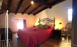a bedroom with a red bed with a red blanket at La Casina de La Casona in Sobrepiedra