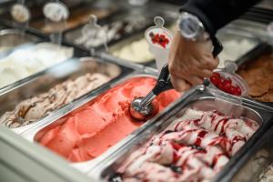 una persona está sirviendo helado en un buffet en Calva B&B Apartments, en Malles Venosta
