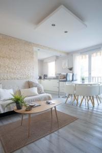 卡布爾的住宿－Appartement Cocooning à Cabourg - Les locations de Proust，客厅配有沙发和桌子