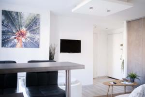 卡布爾的住宿－Appartement Cocooning à Cabourg - Les locations de Proust，客厅配有桌子和电视