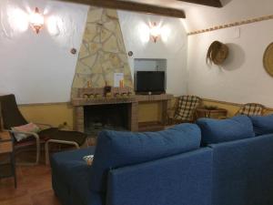 a living room with a blue couch and a fireplace at Cuevas Al Sol in Castilléjar