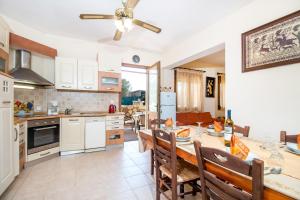 een keuken en eetkamer met een tafel en stoelen bij Cozy Family Home steps from the Beach in Afantou