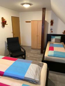 sypialnia z dwoma łóżkami i krzesłem w obiekcie Ubytování MAPE, Rokytnice nad Jizerou, Horní 679, 512 44 w Rokitnicach nad Izerą +4 zdjęcia