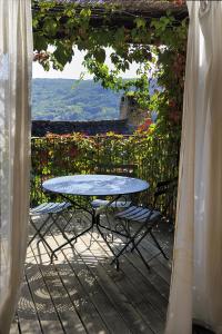 a table and chairs on a patio with a view at Gite de la Cascade in Salles-la-Source