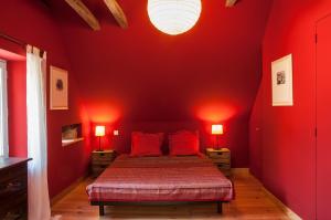 Salles-la-SourceにあるGite de la Cascadeの赤い壁のベッドルーム1室、ベッド1台(赤い枕付)