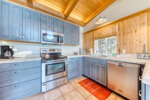 a kitchen with blue cabinets and a wooden ceiling at Grey Haven in Rockaway Beach