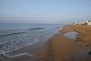 an empty beach with waves coming in from the ocean at Villa Isolde in Triscina