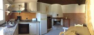 a kitchen with a stove and a fireplace at La Casina de La Casona in Sobrepiedra