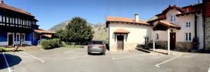 a car parked in a parking lot in front of a building at La Casina de La Casona in Sobrepiedra