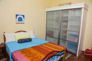 una camera da letto con un letto e una grande finestra di Habibi Nubian Guest House-Nubian Hospitality a Aswan
