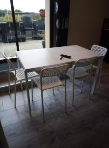 een tafel en stoelen met een witte tafel en een tafel bij gite odeau in Sargé-sur-Braye