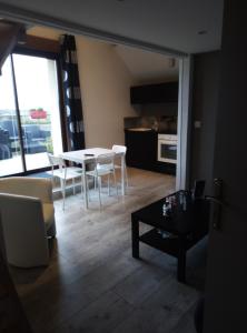 een woonkamer met een tafel en stoelen en een keuken bij gite odeau in Sargé-sur-Braye