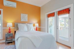 a bedroom with a white bed and two windows at The Lemon Drop in Rosemary Beach