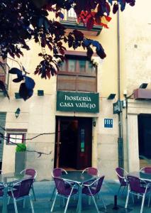 un grupo de mesas y sillas frente a un edificio en Hosteria Casa Vallejo, en Salamanca