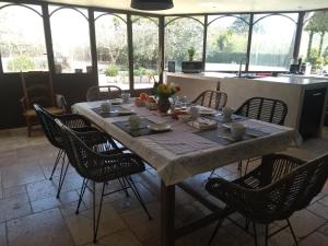 a dining room table with chairs and a kitchen at Mas de Camejean in Lambesc