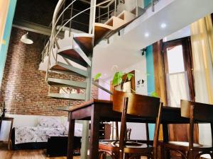 sala de estar con escalera, mesa y sillas en La Casona del Alma en Buenos Aires