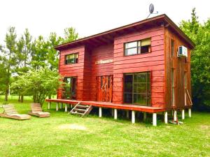 a red tiny house on display in the grass at Cabañas Tunkelen in Punta Indio