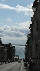 an empty city street with a view of the water at Maison du port, à 100 m de la mer jusqu'à 9 personnes in Cancale