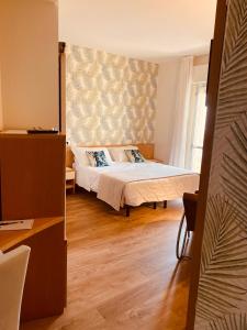 a bedroom with a bed and a window at Hotel Montecarlo - Vista Mare con Area Fitness in Riccione