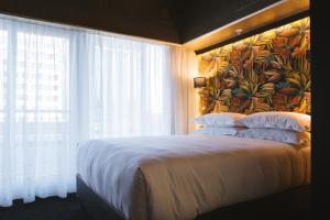 a bedroom with a large bed with a large window at Signature Lux Hotel by ONOMO, Foreshore in Cape Town