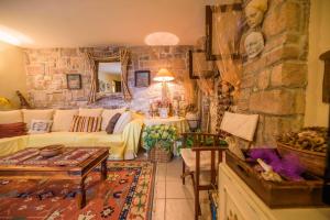 salon z kanapą i kamienną ścianą w obiekcie Seaside Holiday Home Lily w mieście Nijvice