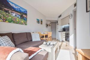 uma sala de estar com um sofá e uma mesa em Acogedor Apartamento Baqueira 1500 em Baqueira-Beret