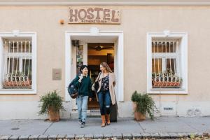 
a man and a woman walking down the street at Vienna Hostel Ruthensteiner in Vienna
