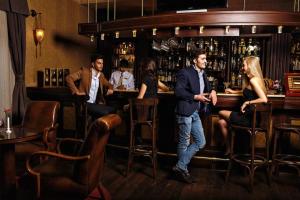 a man and a woman sitting at a bar at Excelsior Hotel & Spa Baku in Baku