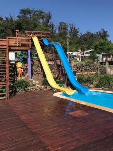 a blue and yellow slide in a playground at Complejo Laderas del Cerro in Piriápolis