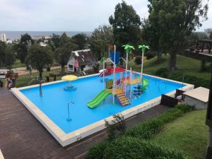 una gran piscina con un tobogán y un parque infantil en Complejo Laderas del Cerro, en Piriápolis
