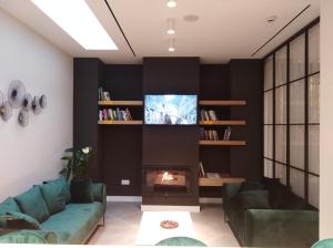 sala de estar con chimenea y TV en Apartamentos Ardales Premium, en Ardales