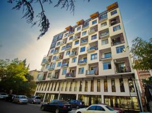 a tall building with cars parked in front of it at Host Net Iverieli in Tbilisi City