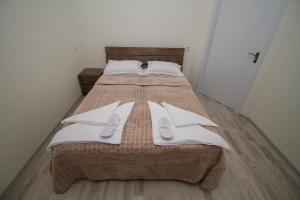 1 dormitorio con 2 camas y toallas blancas. en Host Net Iverieli en Tiflis