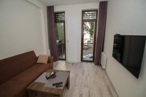 Una sala de estar con un sofá y un televisor. en Host Net Iverieli, en Tiflis