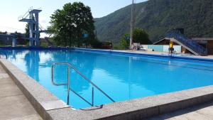 une grande piscine d'eau bleue et des escaliers. dans l'établissement Villa Hillside Apartment, à Jesenice