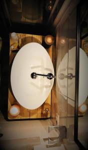 W łazience znajduje się biała umywalka i lustro. w obiekcie Cà Virò w mieście Albosaggia