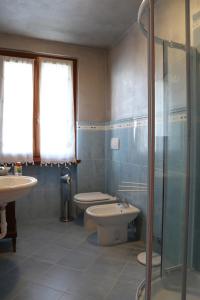 La salle de bains est pourvue de toilettes, d'un lavabo et d'une douche. dans l'établissement Portola la vecchia dimora, à Roncola
