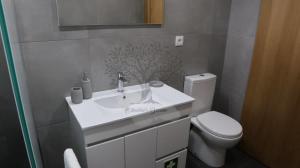 a bathroom with a white sink and a toilet at Oliveira's Dream - Stay Good, Feel Good in Maia +24 photos