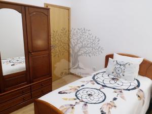 a bedroom with a bed with a wooden cabinet and a bedskirts at Oliveira's Dream - Stay Good, Feel Good in Maia