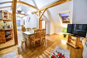 a kitchen and dining room with a table and a tv at Apartament Klara in Zakopane