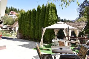 a patio with an umbrella and a table and chairs at Pensiunea Nicolas in Sinaia