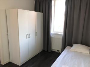 a bedroom with a white cabinet and a bed at White Moon Apartment in Amsterdam