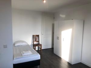 1 dormitorio con cama, silla y armario en White Moon Apartment, en Ámsterdam