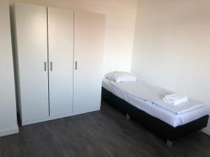 1 dormitorio con 1 cama y armario blanco en White Moon Apartment, en Ámsterdam