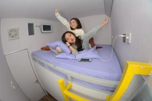 zwei Mädchen, die in einem Krankenhauszimmer auf einem Bett liegen in der Unterkunft Budi House & Food Station in Bandung
